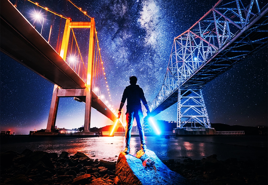 Hombre con sables de luz debajo de un puente
